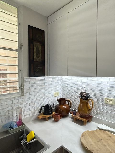 Cocina con gabinetes claros y backsplash en mosaico