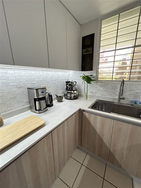 Cocina con fregadero de acero y ventana con vista al patio